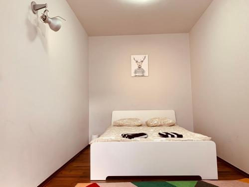 a white bedroom with a bed in a room at Krowoderska Apartment in Krakow