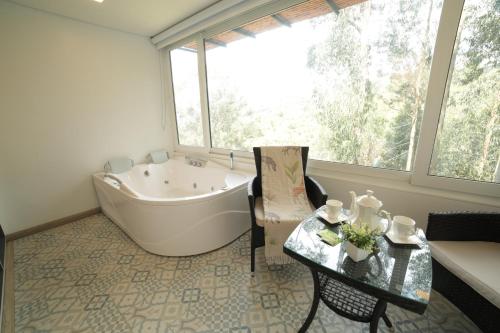 a bathroom with a bath tub and a table and a table sidx sidx at Hotel Boutique Guatika in Tibasosa