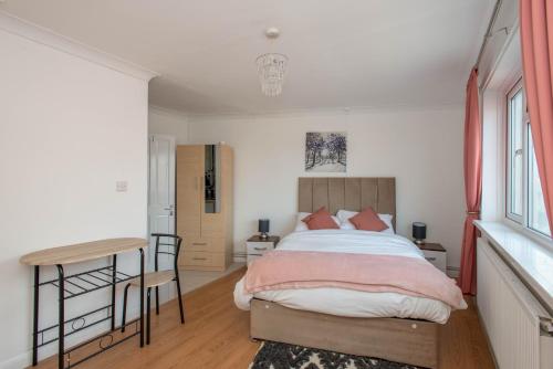a bedroom with a bed and a table and a desk at Modern Studio Apartments in Bromley, Greater London near Tesco and Sundridge Park Station in Bromley
