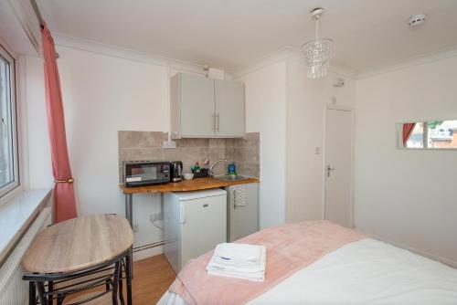 a small kitchen with a bed and a microwave at Modern Studio Apartments in Bromley, Greater London near Tesco and Sundridge Park Station in Bromley