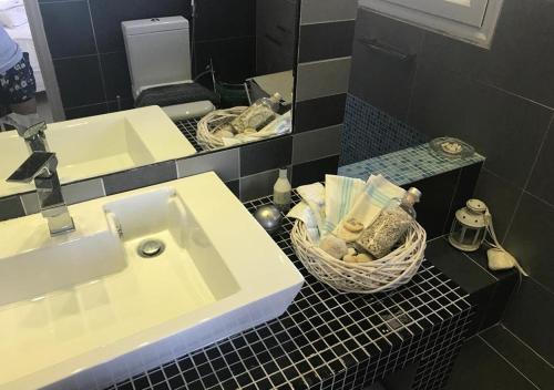 a bathroom with a sink and a basket of towels at Villa Sorina Kefalonia in Svoronata