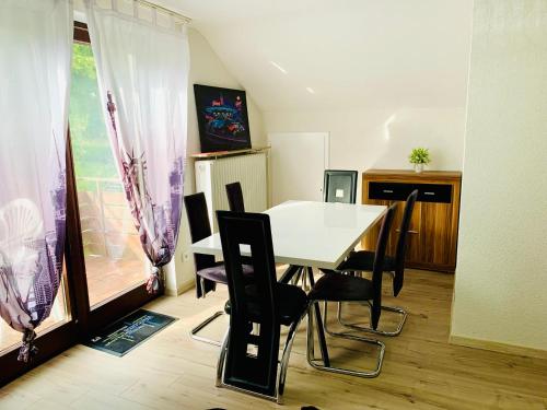 a dining room with a white table and chairs at Villa Goncalves, Komplette Wohnung mit Parkplatz und Wallbox vor der Tür in Calw