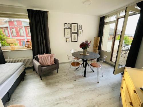 a room with a bed and a table and chairs at Apartment Promenadenkieken mit Pool in Dahme