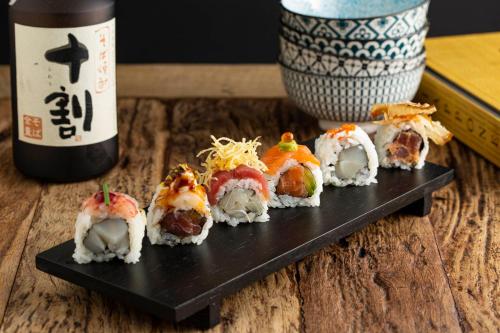 un plato negro de sushi y una botella de vino en Sirena Boutique Hotel, en Gabicce Mare