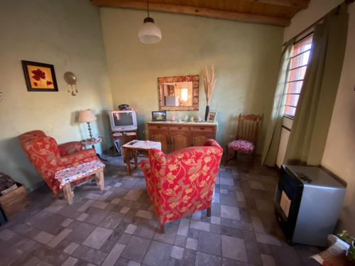 een woonkamer met rode stoelen en een televisie bij La Maru in Villa Giardino