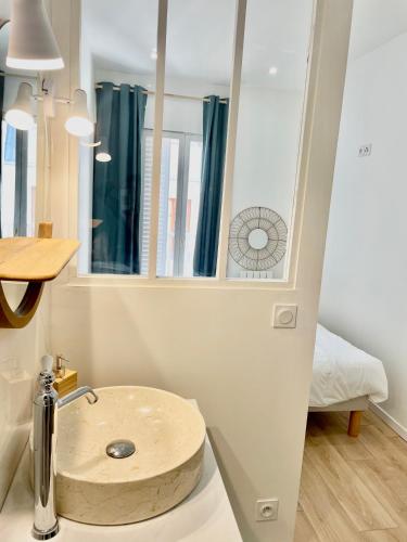 une salle de bain avec un lavabo et un miroir dans l'établissement La suite Caudalie - Charme & Cachet, à Dijon