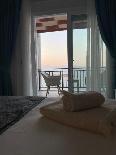 a bedroom with a bed with a view of the ocean at Beach front apartment in Bogazici