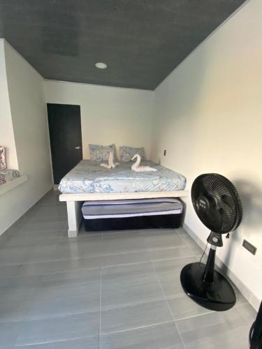a room with a bed with a fan in it at Apartamento vacacional Galeon Doradal in Doradal