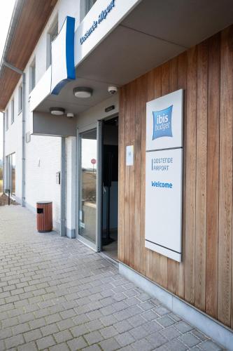 a building with a sign on the side of it at ibis budget Oostende Airport in Ostend