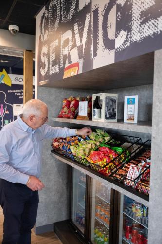 an older man looking at food on a shelf in a store at ibis budget Oostende Airport in Ostend