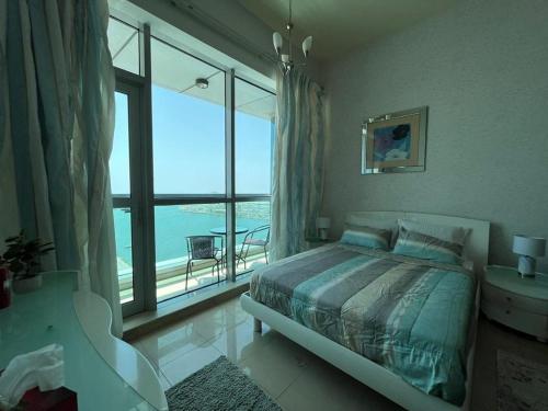 a bedroom with a bed and a large window at luxury studio with amazing seaview in Ras al Khaimah