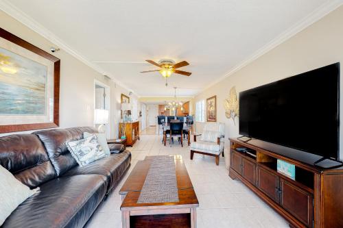a living room with a couch and a flat screen tv at Water View 402 in Clearwater Beach