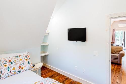 a living room with a couch and a tv on a wall at Our Barn in Marlboro