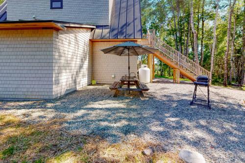 a patio with an umbrella and a table with a chair at Our Barn in Marlboro