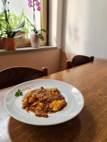 a white plate of food on a table at Restaurant & Apartments Getaway Pri Kobalu in Vipava