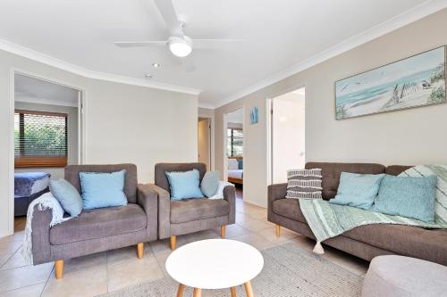 a living room with two couches and a table at Pet Friendly 5 BR Family Home w Pool at Caloundra in Caloundra West