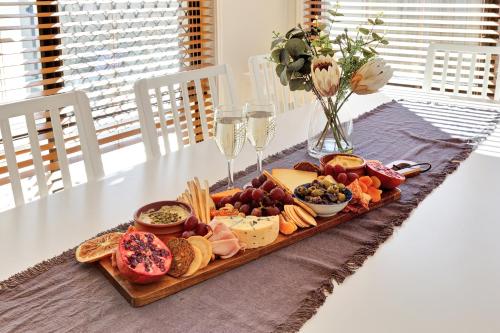 a tray of cheese and other foods on a table at Pet Friendly 5 BR Family Home w Pool at Caloundra in Caloundra West
