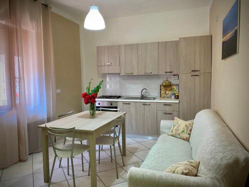 a living room with a couch and a table and a kitchen at Appartamento "Il Geranio" in Trentinara