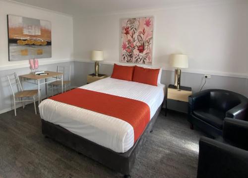a hotel room with a bed and a chair at Centrepoint Midcity Motor Inn in Warwick