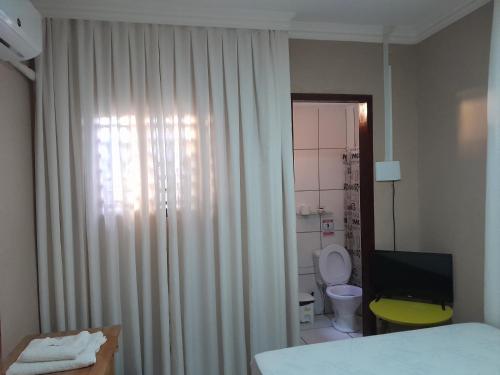 een slaapkamer met een bed, een toilet en een raam bij Casa do Mochileiro Airport Hostel in São Gonçalo do Amarante