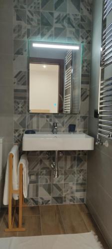 a bathroom with a sink and a tv on the wall at Casa Río Cañón in Meis