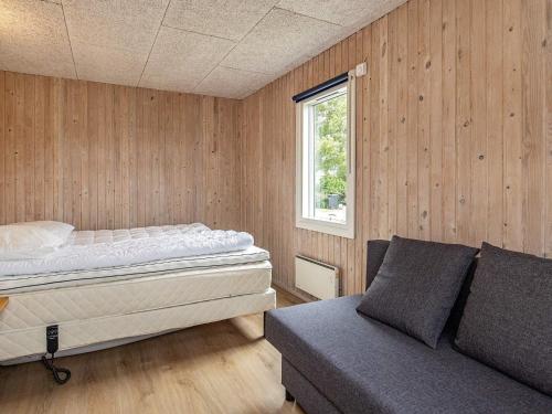 a bedroom with a bed and a couch and a window at 8 person holiday home in Otterup-By Traum in Otterup