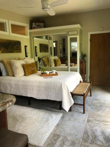 a bedroom with a large bed and a large mirror at The Secret Garden Room in Kapaa