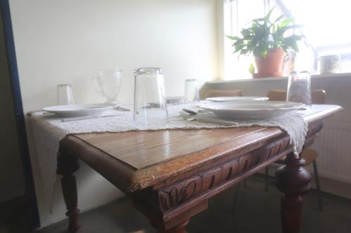 a wooden table with plates and glasses on it at Villa apartment Hafnarfjordur - Ideal for Aurora in Hafnarfjördur