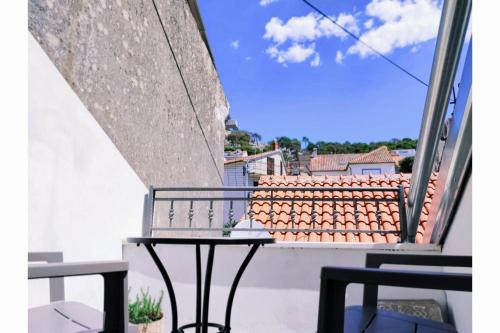 a table on a balcony with a view of a roof at Falcons Nest in Šibenik
