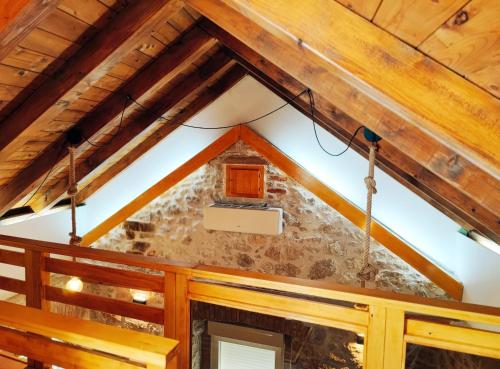 an attic room with a stone wall and wooden beams at Falcons Nest in Šibenik
