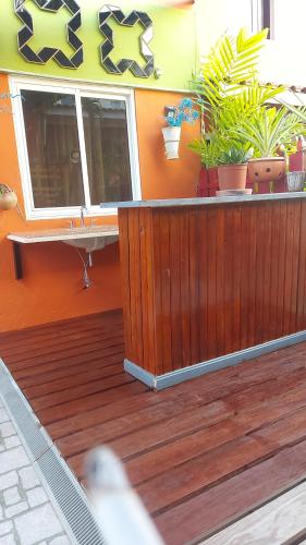 a wooden deck with a window and potted plants at Terrakota Apartments in Willemstad