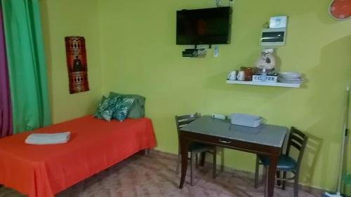 a room with a bed and a table and a tv at Terrakota Apartments in Willemstad
