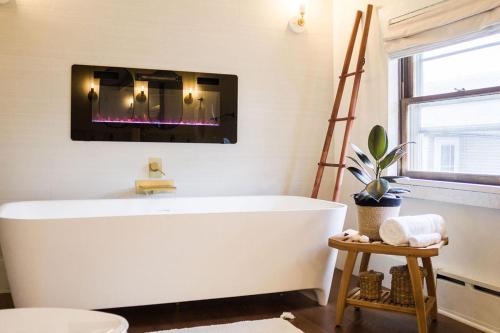 a white bath tub in a bathroom with a fire place at The Loft at Woodhaven Hideaway in Myerstown