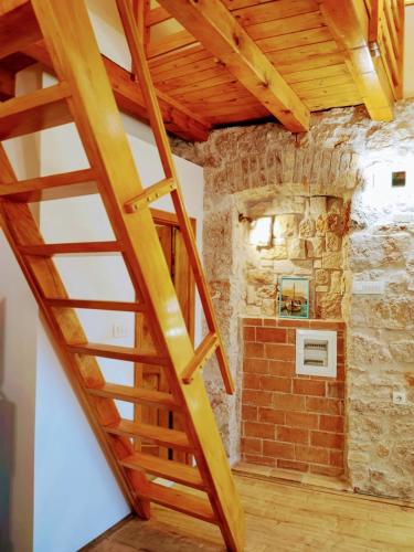 a wooden staircase in a room with a brick wall at Falcons Nest in Šibenik
