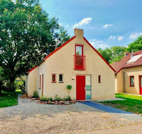 a large brick house with a red door at Green Hills home in Ewijk