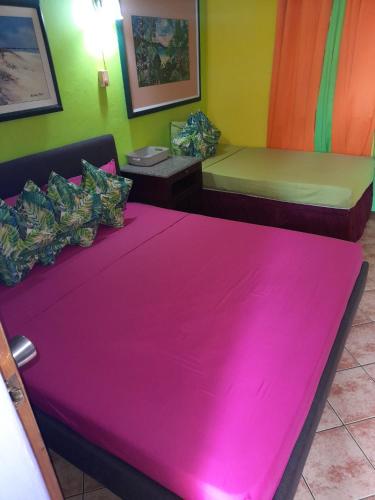 a room with two beds with pink sheets at Terrakota Apartments in Willemstad