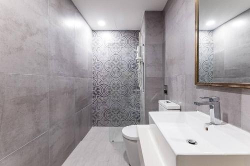 a bathroom with a sink and a toilet and a mirror at Arte Mont Kiara Duplex 4 pax Jacuzzi in Kuala Lumpur