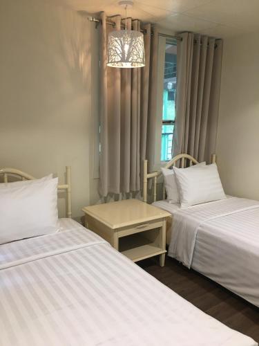 ein Schlafzimmer mit zwei Betten und einem Kronleuchter in der Unterkunft MySpace @Subic in Santa Rita