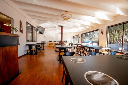 a dining room with tables and chairs and windows at Hearty Center Motel in Katoomba