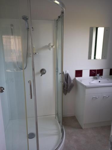 a bathroom with a shower and a sink at Aramatai Gardens in Te Kuiti