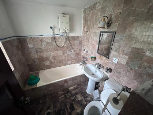 e bagno con lavandino, servizi igienici e vasca. di ES Deurali Resort a Pokhara