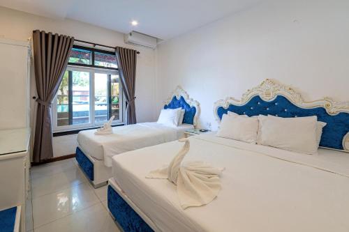 a bedroom with two beds with blue and white at Nostalgia Hotel and Spa in Hoi An