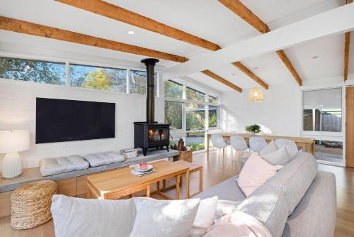 a living room with a couch and a fireplace at Capel Coastal Beauty in Capel Sound