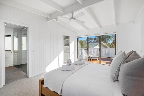 Un dormitorio blanco con una cama grande y un balcón. en Capel Coastal Beauty, en Capel Sound