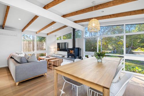 a living room with a wooden table and a couch at Capel Coastal Beauty in Capel Sound