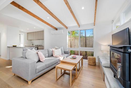 a living room with a couch and a fireplace at Capel Coastal Beauty in Capel Sound