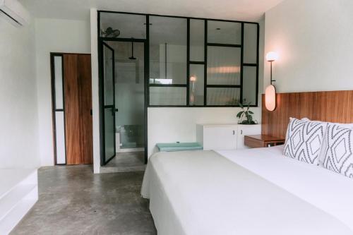 a bedroom with a large white bed and glass walls at Casa Pia in Sayulita