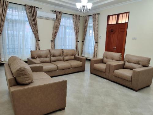 a living room with two couches and two chairs at FAD Home & Apartments in Dodoma