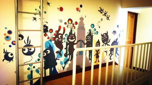 a wall with a mural of cats on a wall at Camellia B&B in Taitung City