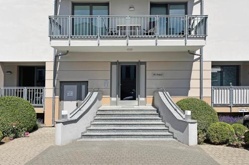 a building with stairs leading up to a balcony at Villa Deichgraf 12 "Meerblick" in Börgerende-Rethwisch